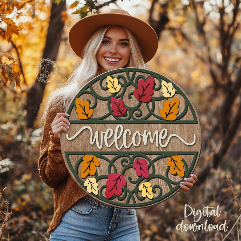 May include: A round wooden welcome sign featuring a dark green scrollwork border and a wood-grain center panel. The sign is decorated with layered autumn leaves in shades of red, orange, and yellow. The word welcome is written in white script.