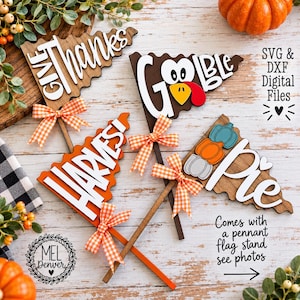 May include: Three wooden pennant-shaped signs on sticks, each featuring orange and white gingham bows. The signs display the text "GIVE THANKS", "GOBBLE", and "Pie" with a turkey graphic and stacked pumpkin icons. Includes "SVG & DXF Digital Files" text.