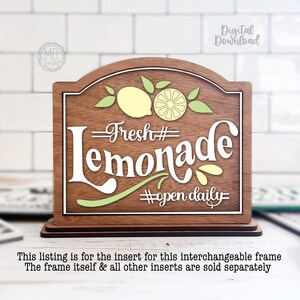 May include: Wooden sign with a brown frame and white lettering that reads "Fresh Lemonade #open daily." The sign features lemon and leaf illustrations in yellow and green. The sign is designed to stand on a flat surface.