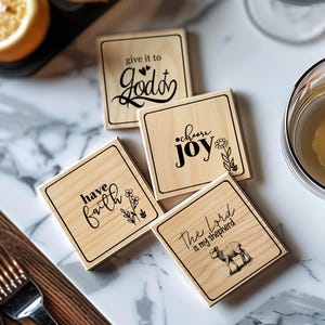 May include: Four wooden coasters with inspirational quotes. The coasters feature the phrases "give it to God", "choose joy", "have faith", and "the Lord is my shepherd".