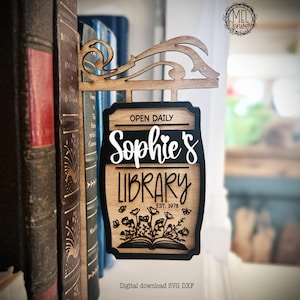 May include: Wooden sign for "Sophie's Library" with a decorative top, hanging in front of a bookshelf. The sign has a black border, with the words "Open Daily", "Sophie's", and "Library" in white. The sign also includes the text "EST. 1978".