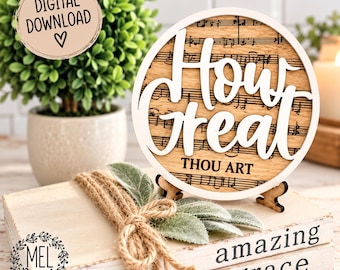 Peut inclure: Un panneau circulaire en bois avec le texte How Great THOU ART en lettres blanches en relief sur un fond de notes de musique imprimées. Le panneau est soutenu par un petit support en bois et posé sur une pile de livres blancs liés par de la ficelle.