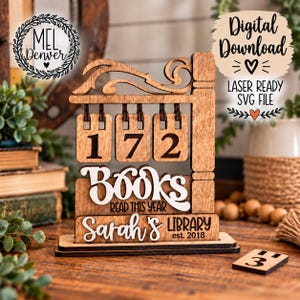 Puede incluir: Un letrero de madera cortado con láser que presenta un contador colgante con los números 172, el texto "BOOKS READ THIS YEAR" y "Sarah's LIBRARY est. 2018". El diseño incluye una pieza de madera separada con el número 3 y volutas decorativas.