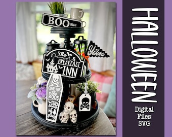 May include: A black three-tiered tray decorated with Halloween-themed signs including BOO Blvd, The Dead & Breakfast Inn, and a coffin-shaped sign reading Come for the Boos Stay because we slay. Includes skull figurines and a Yikes pennant.