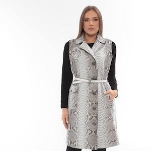 Könnte beinhalten: Eine weiße Keramik-Tasse mit schwarzem Henkel und dem Text "But First, Coffee" in schwarzer, handschriftlicher Schrift. Die Tasse steht auf einer weißen Oberfläche.