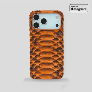 Könnte beinhalten: Orange-braune, strukturierte Handyhülle mit Schlangenhautmuster. Die Hülle hat eine rechteckige Form mit abgerundeten Ecken und einem Kameraausschnitt. Der Text "Made for MagSafe" ist zu sehen.