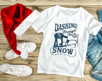 May include: White t-shirt with a blue graphic of a Star Wars AT-AT walking through snow with the text "Dashing Through The Snow".