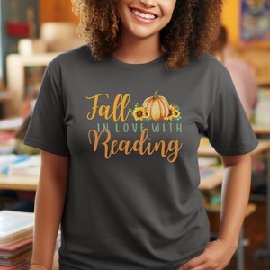 May include: A dark gray t-shirt with the text "Fall in love with reading" and a graphic of a pumpkin with sunflowers.