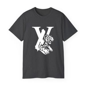 May include: Charcoal grey t-shirt with a white graphic. The graphic design incorporates the letter "X" and a detailed illustration of a tiger. The tiger is roaring, with its teeth bared, and is positioned within the letter's design.