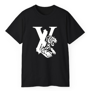 May include: Black t-shirt with a white graphic. The design features a large white "X" and a tiger illustration. The tiger is roaring, with its teeth bared. The shirt is made of a soft material.