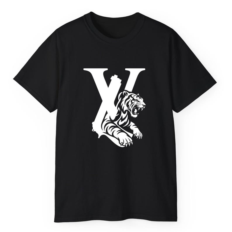 May include: Black t-shirt with a white graphic. The design features a large white "X" and a tiger illustration. The tiger is roaring, with its teeth bared. The shirt is made of a soft material.