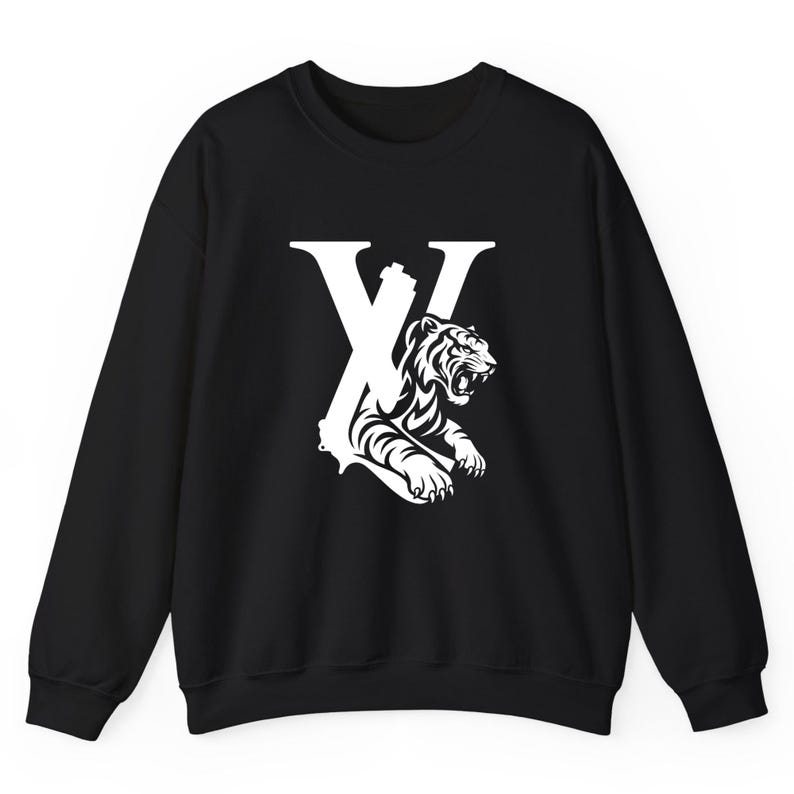 May include: Black sweatshirt with a white graphic. The graphic features a stylized letter "X" with a roaring tiger design. The tiger is in a detailed, black and white illustration. The sweatshirt has long sleeves and a crew neck.