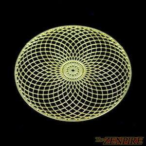 May include: A gold-coloured, circular decorative piece with a geometric, lattice-like design. The centre features a smaller, detailed pattern. The text "The ZENPIRE" is visible in the lower right corner against a black background.