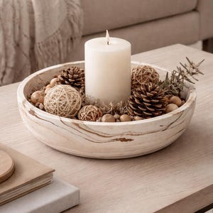 May include: A white ceramic mug with a black handle and the text "But first, coffee" in a black, handwritten-style font. The mug is on a white surface.