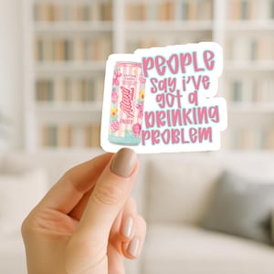 May include: A sticker featuring a pink and white energy drink can with the text "Alani Energy" and "Cotton Candy" flavor. The sticker also includes the phrase "People say I've got a drinking problem" in pink lettering.