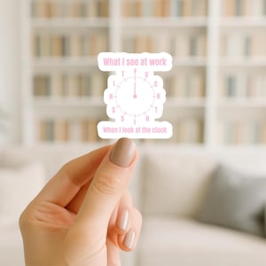 May include: A pink sticker with the text "What I see at work" above a clock design. The clock face has the letters "T", "F", "U", "C", "K", "T", "H", "S", "I", "H" in place of numbers. Below the clock is the text "When I look at the clock".