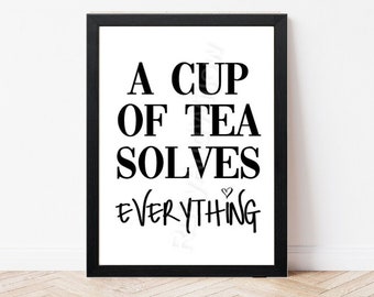 May include: Black and white framed print with the text "A cup of tea solves everything" with a small heart symbol.