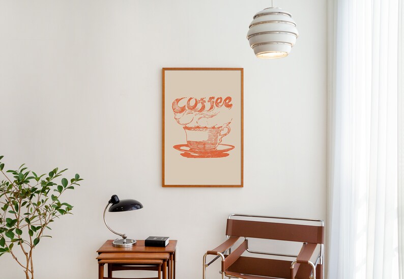 May include: A framed print with a stylized illustration of a coffee cup with steam forming the word "coffee" in red on a cream background.