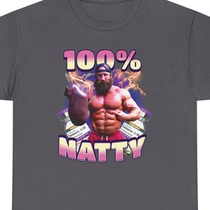 Puede incluir: Una camiseta gris oscuro con un gráfico de un hombre musculoso sosteniendo una jeringa grande. El gráfico está rodeado de jeringas más pequeñas y el texto "100% NATTY" en rosa y morado.