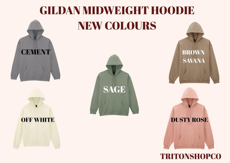 Op de afbeelding: Een display van Gildan midweight hoodies in nieuwe kleuren. De hoodies worden getoond in cement, bruin savana, salie, gebroken wit en dusty rose. Elke hoodie heeft een capuchon en een voorzak. De tekst "GILDAN MIDWEIGHT HOODIE NEW COLOURS" staat bovenaan.