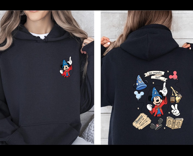 Op de afbeelding: Marineblauwe hoodie met een kleine geborduurde Mickey Mouse als tovenaar op de voorkant. De achterkant toont een kleurrijke afbeelding met Mickey, een tovenaars hoed en de tekst "Some imagination, Huh?" Een leuk, grillig ontwerp.