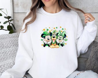 May include: A white long-sleeve sweatshirt featuring a graphic print of Mickey Mouse, Pluto, and Minnie Mouse dressed in green St. Patrick's Day attire. The characters are surrounded by green shamrocks and gold coins, with the text Lucky You.