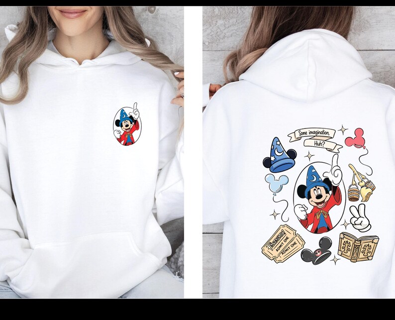 Op de afbeelding: Witte hoodie met een Mickey Mouse-afbeelding op de voor- en achterkant. De voorkant heeft een klein Mickey Mouse-ontwerp. De achterkant heeft een groter ontwerp met Mickey Mouse, een tovenaars hoed en de tekst "Some imagination, Huh?"