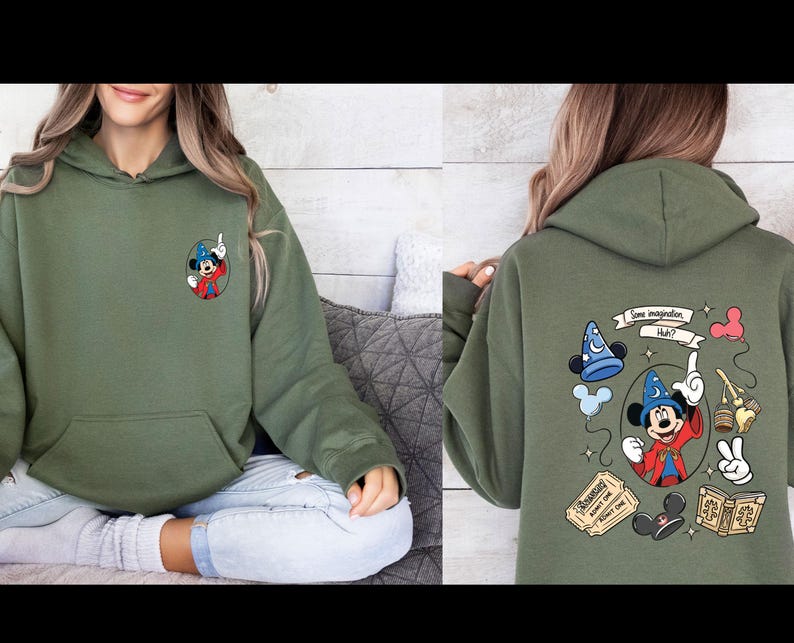 Op de afbeelding: Olijfgroene hoodie met een Mickey Mouse-ontwerp. De voorkant heeft een kleine Mickey Mouse-afbeelding, terwijl de achterkant een groter ontwerp heeft met de tekst "Some imagination, Huh?" en andere gerelateerde illustraties. De hoodie heeft een voorzak.