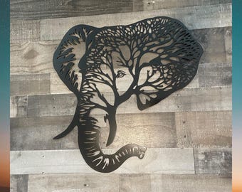 May include: Black metal wall art sculpture of an elephant's head with a tree design inside the silhouette.