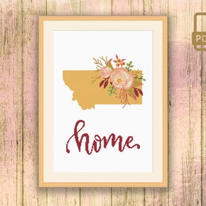 May include: Cross stitch pattern featuring a floral design with pink roses and burgundy leaves, a gold outline of the state of Montana, and the word "home" in burgundy script.