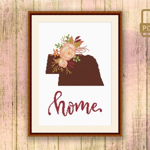 May include: A cross-stitch pattern featuring a floral design with pink flowers and green leaves, a brown silhouette of the state of Oklahoma, and the word "home" in cursive script.