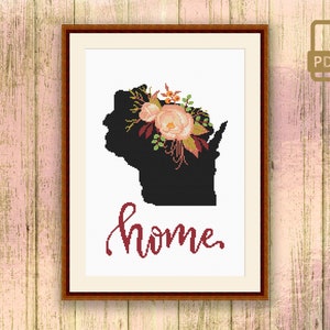 May include: Cross stitch pattern featuring a black silhouette of the state of Wisconsin with a floral wreath on top and the word "home" written in cursive below.
