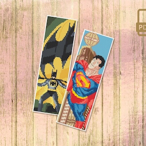 May include: Two cross-stitch bookmark patterns featuring Superman and Batman. The Superman bookmark pattern shows Superman flying with the Daily Planet building in the background. The Batman bookmark pattern shows Batman standing in a dark, shadowy setting.
