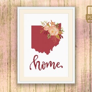 Pode incluir: Padrão de ponto cruz com um contorno vermelho do estado de Ohio com um buquê de flores no canto superior direito. O texto "home" está escrito em itálico abaixo do contorno do estado.