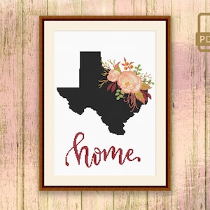 May include: Framed cross-stitch art featuring the silhouette of Texas in black, adorned with a floral arrangement in peach, pink, and burgundy. The word "home" is stitched in a cursive font below the Texas outline.