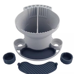 May include: A gray plastic organizer with a divided top section for storing pens or pencils. The organizer has a removable tray and three smaller containers, all in a dark gray color.