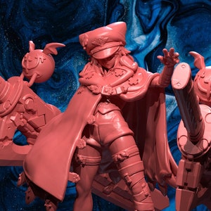 May include: A pink 3D printed miniature of a female figure wearing a red cape and a military cap. She is holding two large weapons with a skull design. The miniature is on a blue and white background.