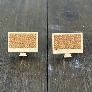 Puede incluir: Dos pendientes de madera con forma de monitor de ordenador. Los monitores son de color marrón con textura de madera.