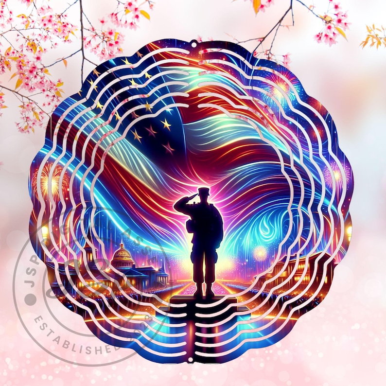 May include: A metal wind spinner with a patriotic design. The spinner features a silhouette of a soldier saluting in front of an American flag with fireworks in the background. The design is in shades of red, white, and blue.