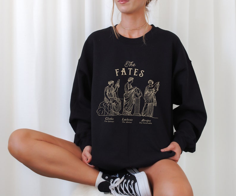May include: Black sweatshirt with a graphic print of three women, labeled "The Fates" with their names and titles: Clotho, The Spinner, Lachesis, The Allotter, and Atropos, The Inevitable.