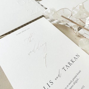 Pode incluir: Convite de casamento branco com texto em relevo que diz "It was always you. The wedding of [name] and [name]" e a data "2023".