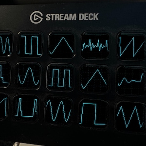Op de afbeelding: Een zwarte Stream Deck-bedieningsconsole met vijftien vierkante toetsen in een raster. Elke toets toont een unieke, lichtgevende cyaan golfvormgrafiek tegen een donkere achtergrond, die verschillende elektronische signalen en audiofrequenties weergeeft.