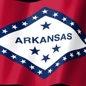 May include: The state flag of Arkansas features a red field with a central white diamond bordered in blue. Inside the diamond, the word ARKANSAS is printed in blue, surrounded by twenty-five white stars, with four blue stars arranged in the center.