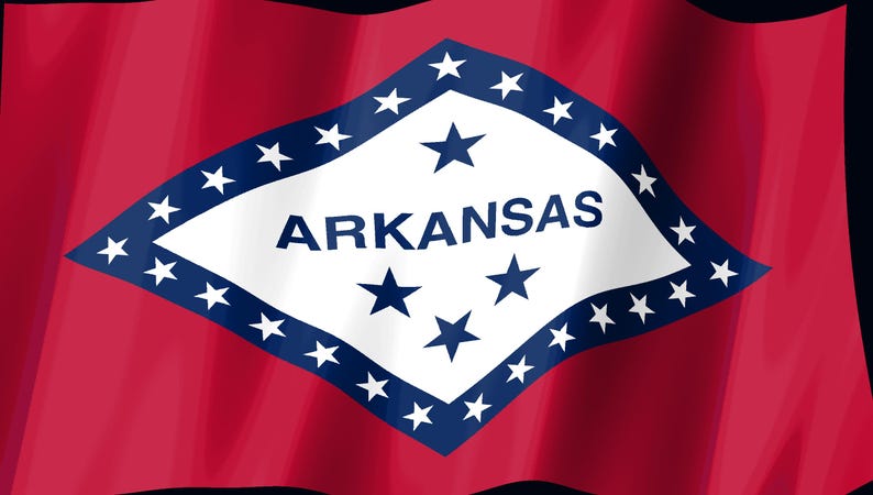 May include: The state flag of Arkansas features a red field with a central white diamond bordered in blue. Inside the diamond, the word ARKANSAS is printed in blue, surrounded by twenty-five white stars, with four blue stars arranged in the center.