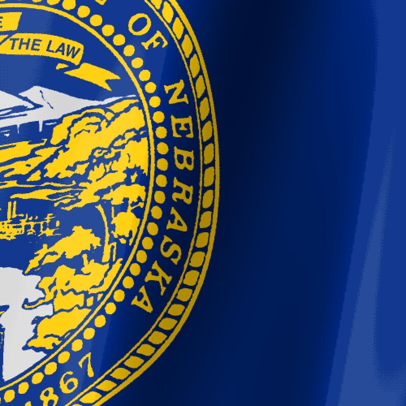 May include: A deep blue flag featuring the state seal of Nebraska in yellow. The seal displays a mountain landscape, a steamboat on a river, and a train, with a banner reading THE LAW and the text GREAT SEAL OF THE STATE OF NEBRASKA 1867.