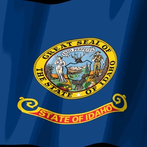 K&ouml;nnte beinhalten: Die Staatsflagge von Idaho zeigt ein tiefblaues Feld mit dem Staatssiegel in der Mitte. Das Siegel zeigt eine Frau und einen Mann neben einem Schild mit einer Landschaft, gekr&ouml;nt von einem Hirschkopf. Darunter steht auf einem roten Banner STATE OF IDAHO.