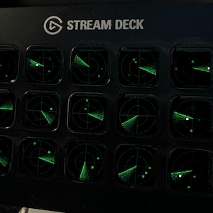 Pode incluir: Uma consola de controlo Stream Deck preta com quinze teclas quadradas dispostas numa grelha. Cada tecla apresenta um gr&aacute;fico de ecr&atilde; de radar verde brilhante com linhas circulares e pequenos pontos quadrados num fundo escuro.