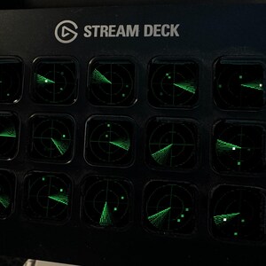 May include: A black Stream Deck control console featuring fifteen square keys arranged in a grid. Each key displays a glowing green radar screen graphic with circular grid lines and scanning beams, set against a dark background.