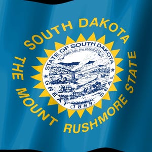 May include: The blue flag of South Dakota features a central yellow sunburst surrounding the state seal. The seal depicts a landscape with a river, hills, and a mine. Text reads THE MOUNT RUSHMORE STATE, SOUTH DAKOTA, and STATE OF SOUTH DAKOTA.