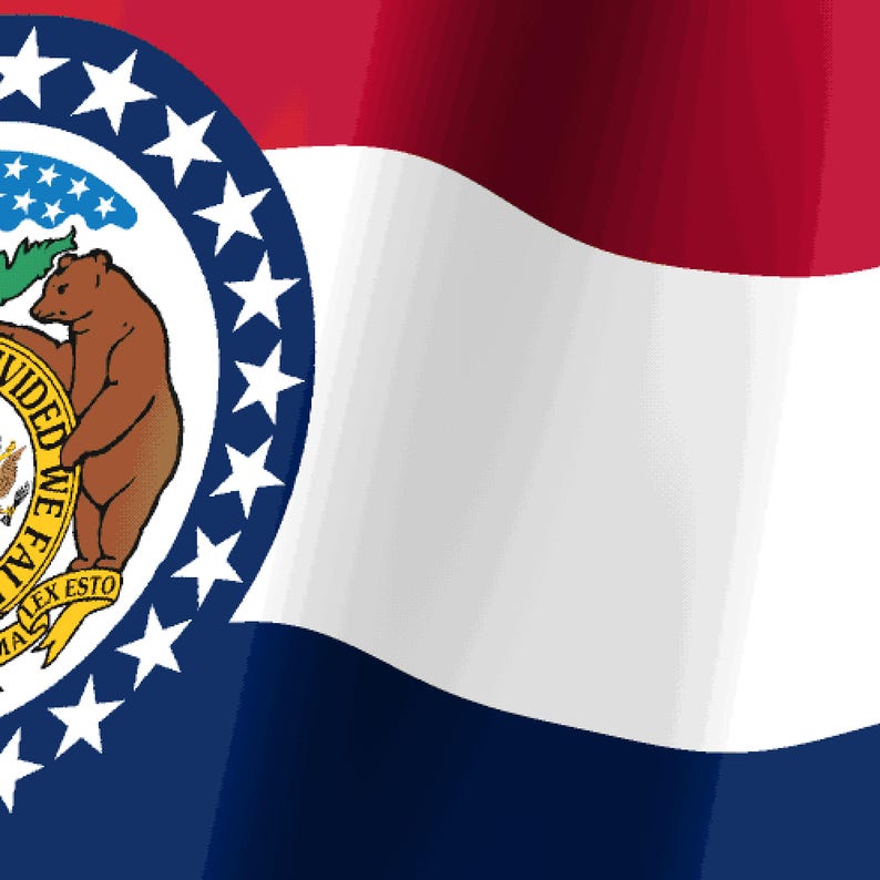 K&ouml;nnte beinhalten: Die Staatsflagge von Missouri zeigt horizontale Streifen in Rot, Wei&szlig; und Blau. Ein kreisf&ouml;rmiges Emblem in der Mitte enth&auml;lt das Staatssiegel mit zwei braunen B&auml;ren, einem Schild und dem Text "UNITED WE STAND DIVIDED WE FALL", umgeben von Sternen.